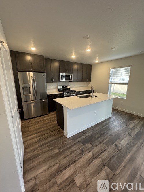 A kitchen with a refrigerator, microwave, and oven.