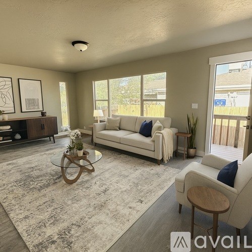 A living room with a white couch and a glass coffee table.