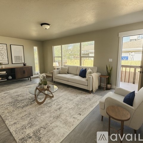A living room with a white couch and a glass coffee table.