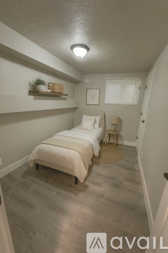 A bedroom with a bed and a chair.