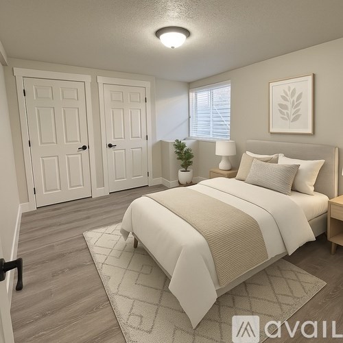 A bedroom with a bed, two doors, and a window.