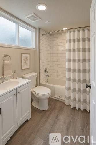 A bathroom with a toilet, sink, and shower.