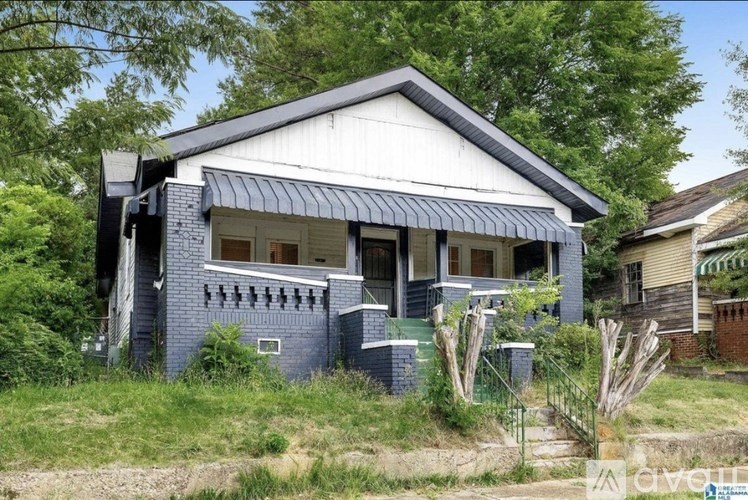 A blue house with a white roof and a black awning.