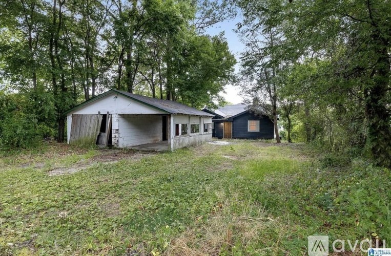 A house in a wooded area with a white and blue exterior.