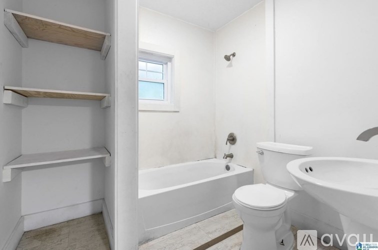 A white bathroom with a toilet, sink, and bathtub.