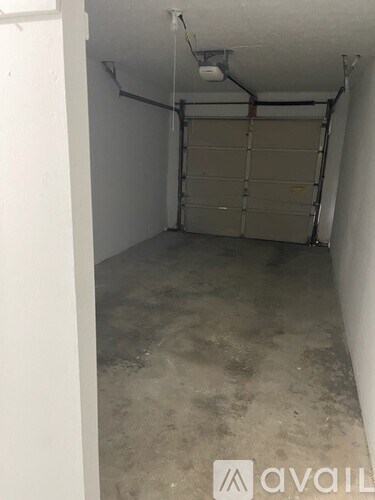 A garage with a closed door and a white wall.