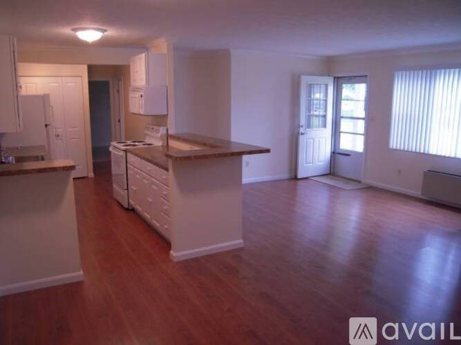 A kitchen with white cabinets and a wooden island.