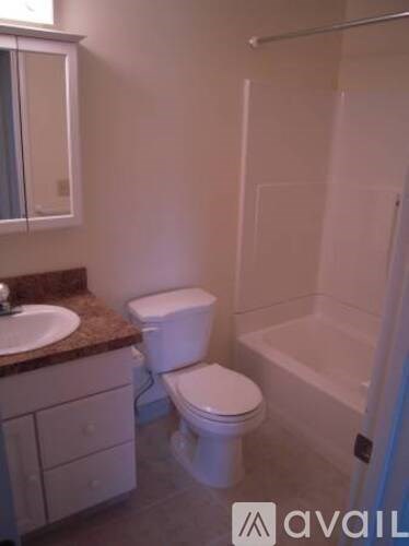 A bathroom with a toilet, sink, and shower.