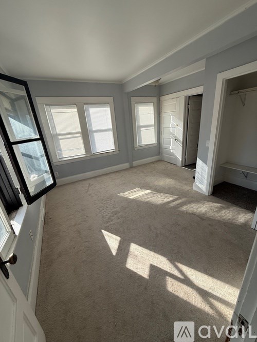 A room with a carpeted floor and a large window.