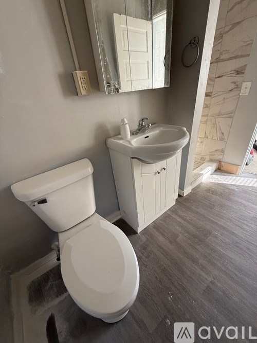A white toilet and sink in a bathroom.