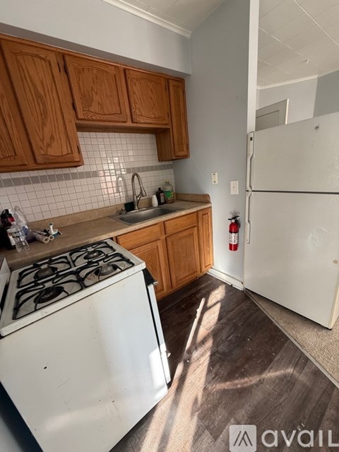A kitchen with wooden cabinets and a white stove.