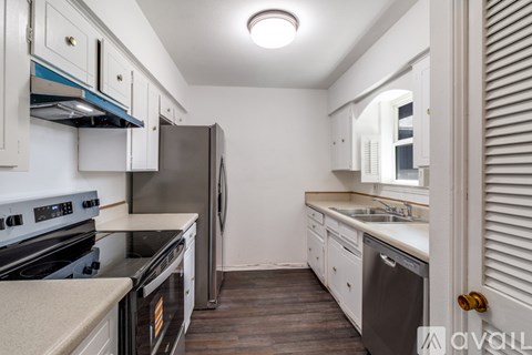 A kitchen with a stove top oven and a refrigerator.