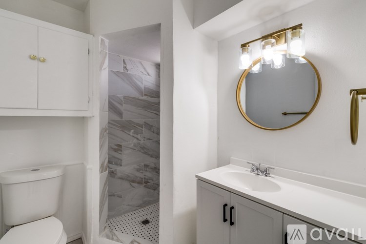 A bathroom with a toilet, sink, and mirror.