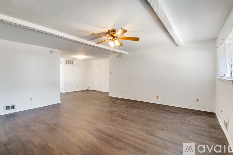 A room with wooden flooring and a ceiling fan.