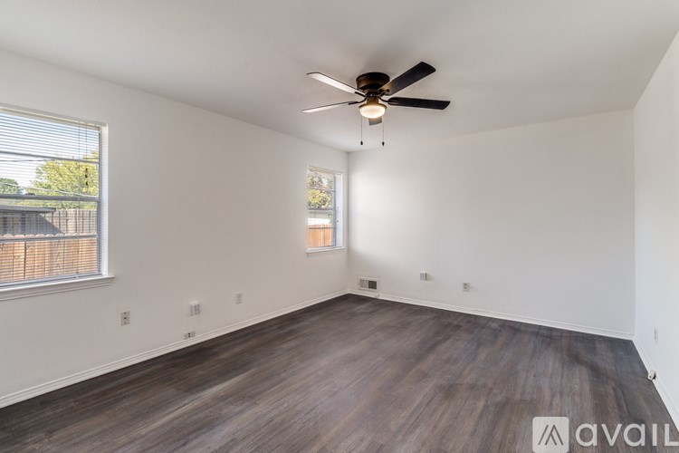 A room with a ceiling fan and wooden flooring.