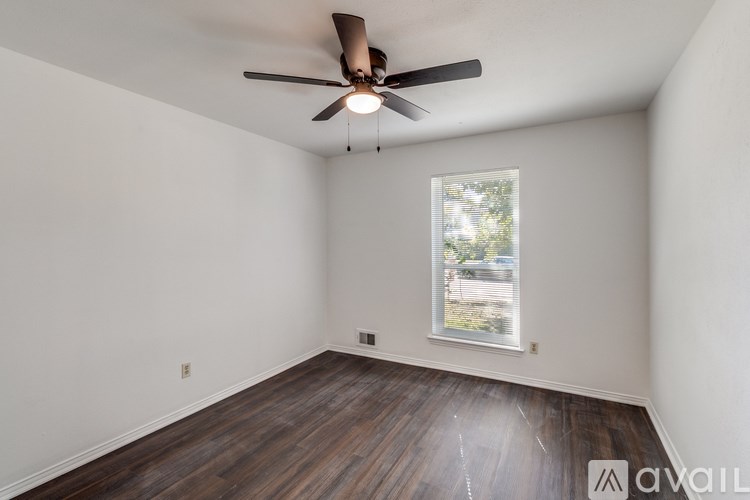 A room with a ceiling fan and a window.