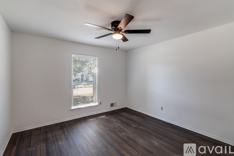 A room with a ceiling fan and a window.