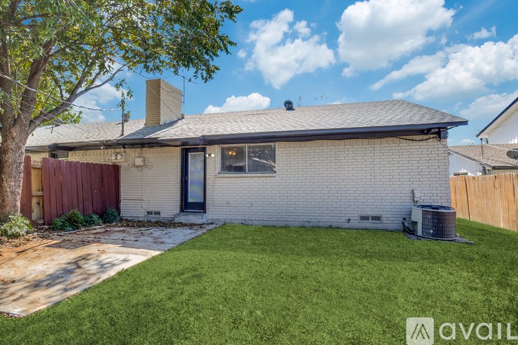 A house with a red fence and a tree in front.