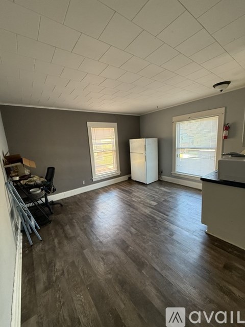 A room with wooden flooring and a window with blinds.