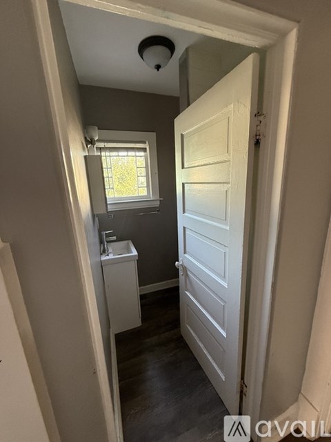 A small bathroom with a sink and a window.