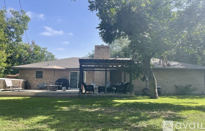 A house with a patio and a tree in front.