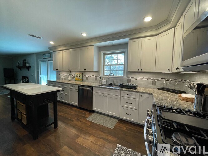 A kitchen with a white countertop and wooden cabinets.