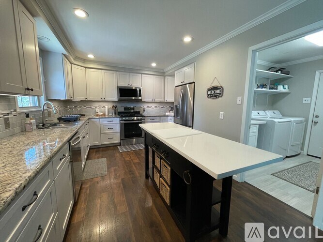 A kitchen with a white countertop and wooden floors.