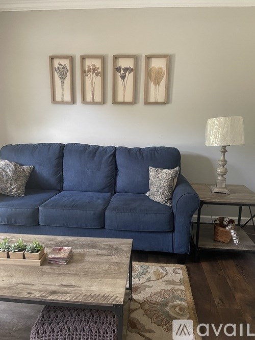 A blue couch with a wooden table in front of it.