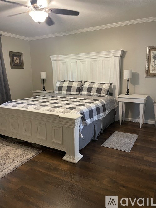A bedroom with a bed, nightstands, and a ceiling fan.