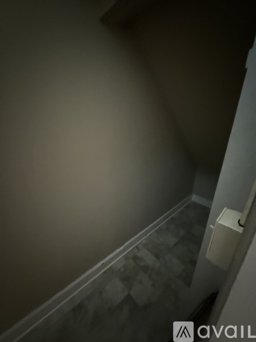 A stairwell with a metal railing and tiled steps.