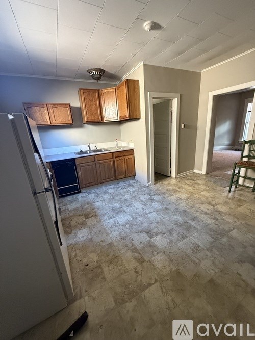 A kitchen with wooden cabinets and a tiled floor.