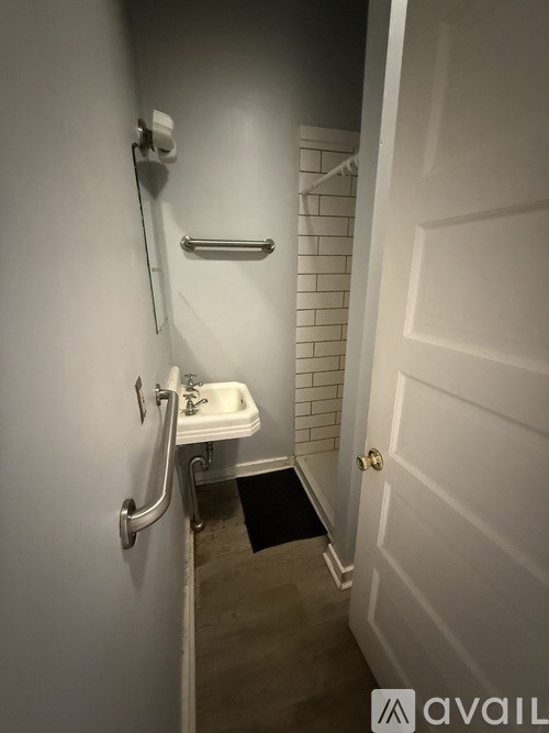 A small white sink in a narrow bathroom.