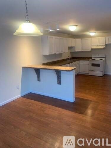 A kitchen with white cabinets and a wooden island.