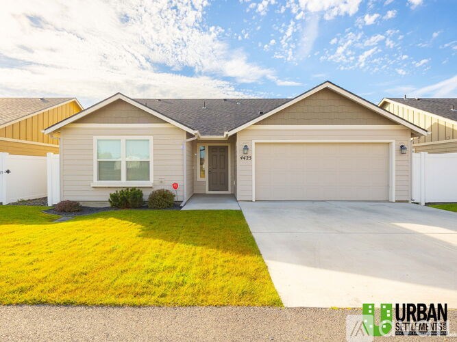 A house with a garage and a driveway in front of it.