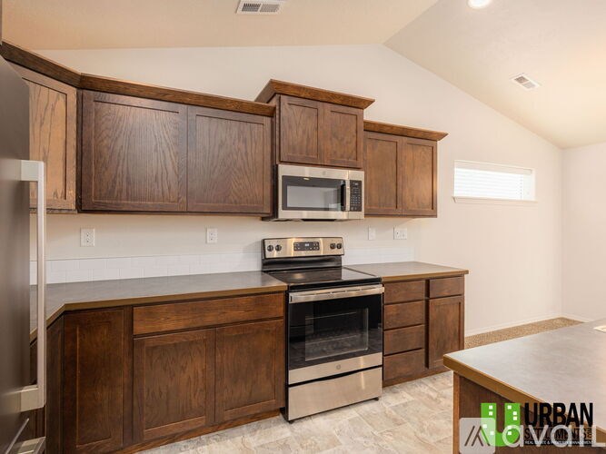 A kitchen with wooden cabinets and a stainless steel oven.