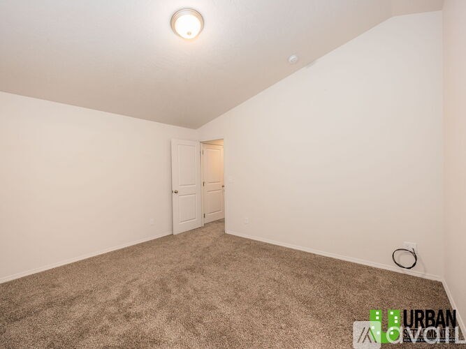 A room with a carpeted floor and a door in the background.