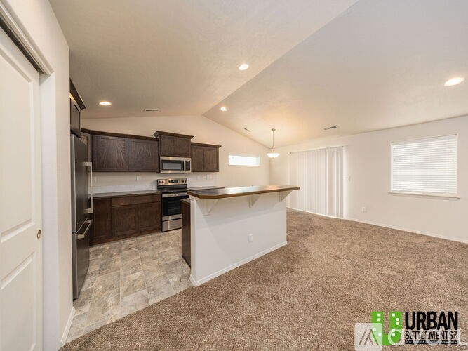 A spacious kitchen with brown cabinets and a white island.