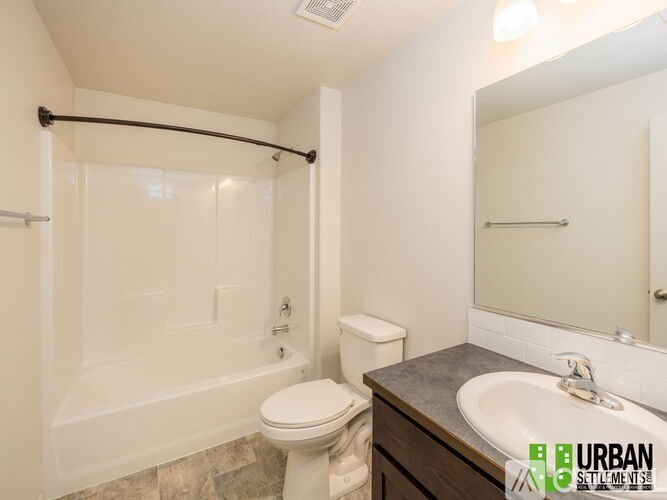 A bathroom with a toilet, sink, and bathtub.