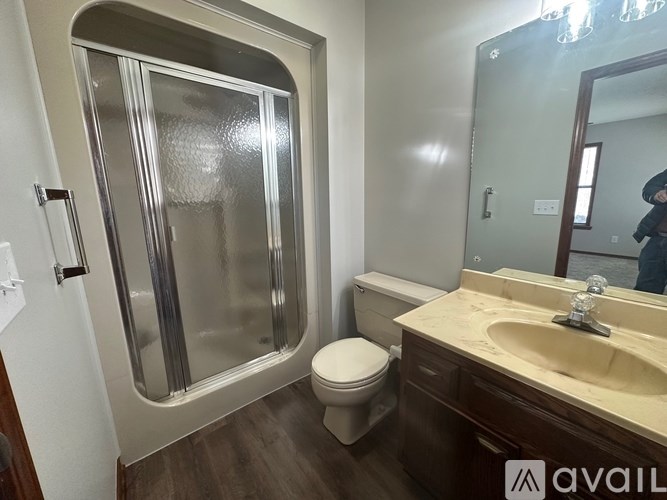 A bathroom with a toilet, sink, and shower.