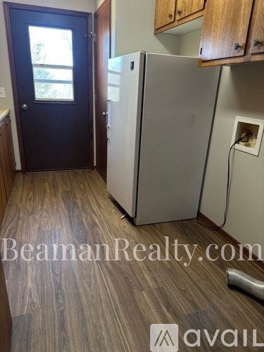 A kitchen with a white fridge and wooden cabinets.