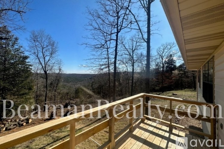 A wooden deck overlooks a wooded area.