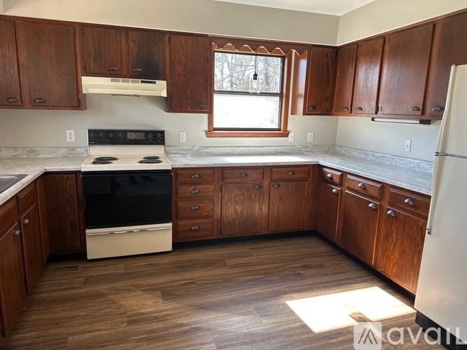 A kitchen with wooden cabinets and a white refrigerator.