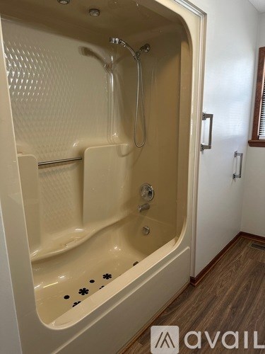 A white bathtub with a shower head and a shower curtain.