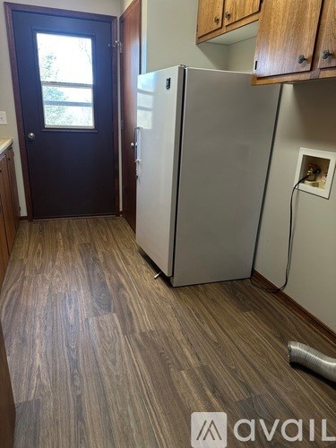 A kitchen with a white fridge and wooden cabinets.
