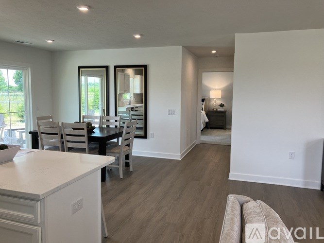 A well-lit, spacious living room with a dining area and a kitchenette.