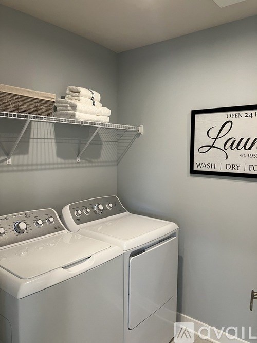 A laundry room with a washer and dryer and a sign that says "Laundry" on the wall.