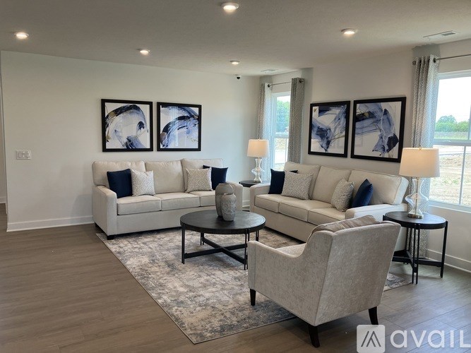 A living room with two couches, a coffee table, and two chairs.