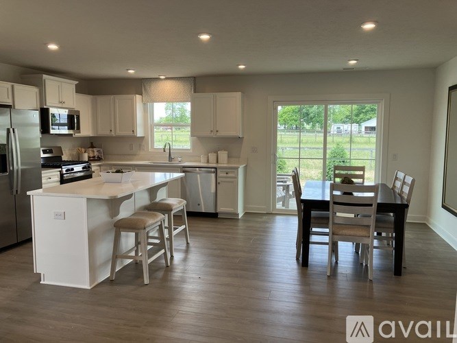 A kitchen with white cabinets and a wooden floor.