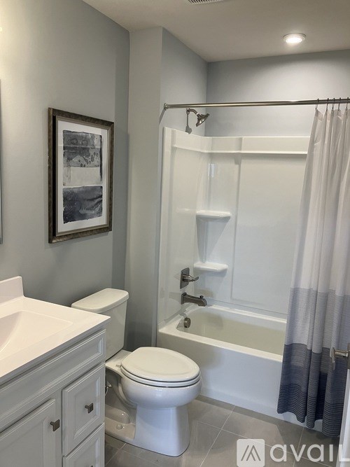 A bathroom with a toilet, sink, and bathtub.
