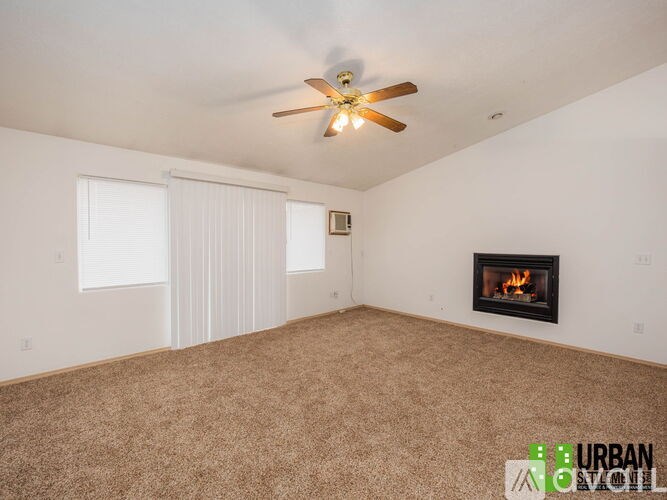 A room with a fireplace and a ceiling fan.